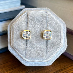 
                  
                    Load image into Gallery viewer, These bezel asscher cut studs are shown in 14 kt yellow gold vermeil.
                  
                