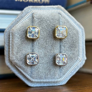 
                  
                    Load image into Gallery viewer, These bezel asscher cut studs are available in either sterling silver or 14 kt yellow gold vermeil.
                  
                