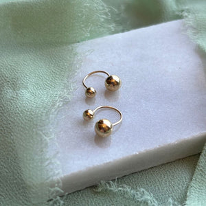 
                  
                    Load image into Gallery viewer, Alma 14kt yellow gold studs shown on a white marble tray with green linen draped around
                  
                