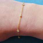 Yellow gold chain bracelet with crystals shown on model's right wrist.