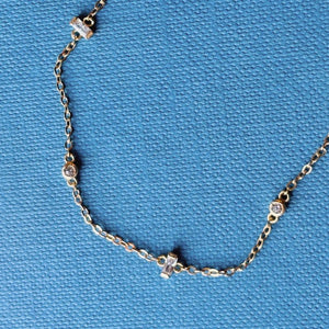 
                  
                    Load image into Gallery viewer, Yellow gold chain bracelet with bezet set and half bezel set crystals shown on blue book background.
                  
                