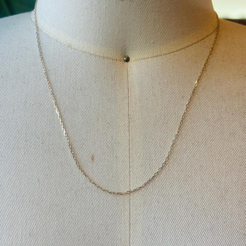 This 14 kt solid yellow gold chain is shown on an off white bust for scale.