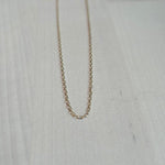 This 14 kt solid yellow gold chain is shown on wooden background.