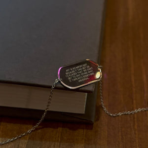 
                  
                    Load image into Gallery viewer, Sterling silver engraved dog tag bracelet shown on gray book and wood desk.
                  
                