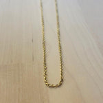 This 14 kt solid yellow gold chain on a wooden background