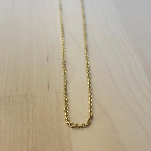 
                  
                    Load image into Gallery viewer, This 14 kt solid yellow gold chain on a wooden background
                  
                