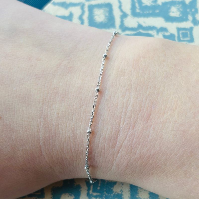 Shown on a right wrist, a sterling silver bracelet with small balls spaced evenly.