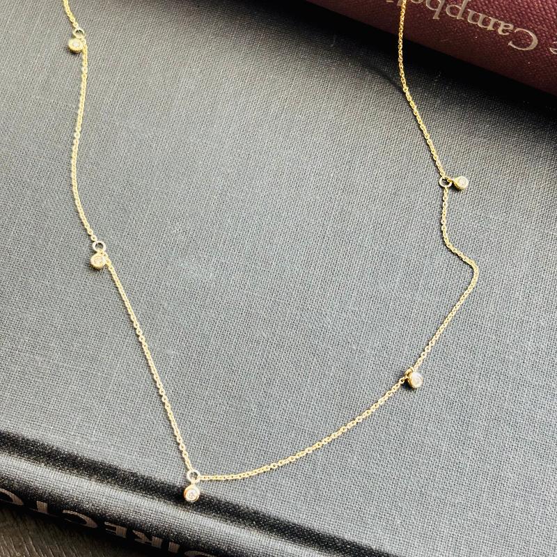 Our Calico necklace is set in solid 14 kt yellow gold and has 5 bezel set diamonds attached.