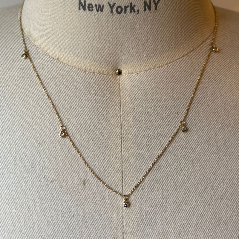 
                  
                    Load image into Gallery viewer, Solid 14 kt yellow gold necklace with 5 bezel set diamonds attached shown on bust for scale.
                  
                