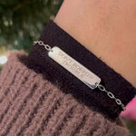 Sterling silver bar bracelet engraved and shown on the model's left wrist