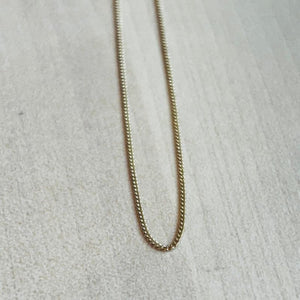 
                  
                    Load image into Gallery viewer, This 14 kt solid yellow gold chain is shown on wooden background.
                  
                