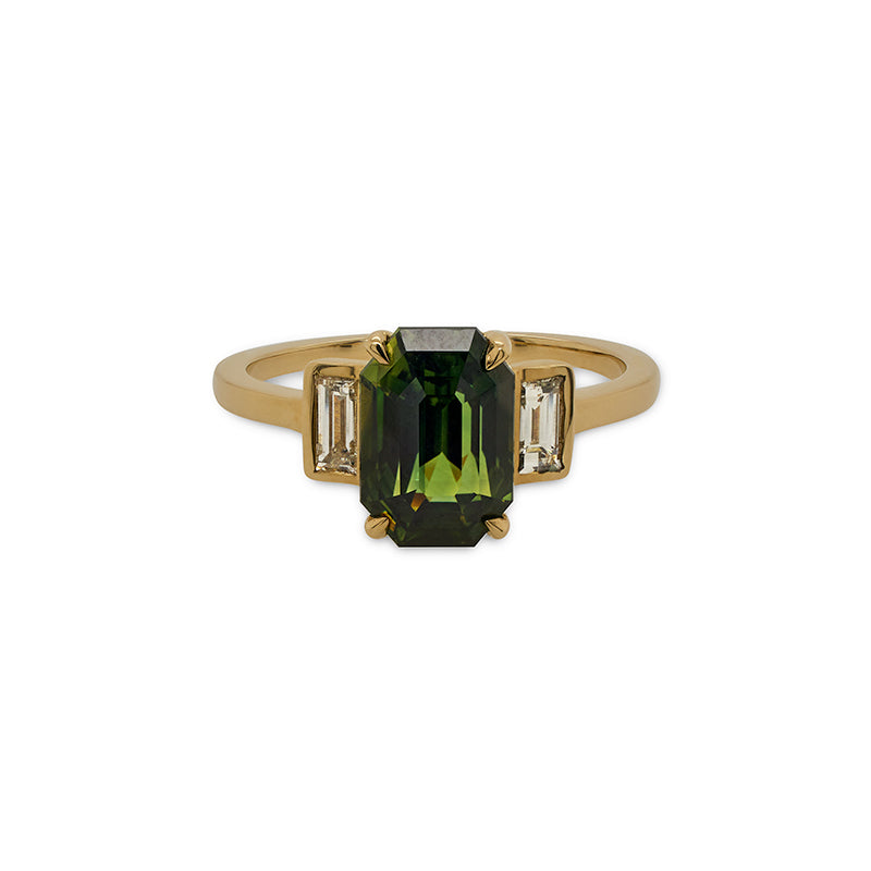 Front view of a bi-color green/yellow emerald cut sapphire and baguette cut diamond ring cast in 14 kt yellow gold. 