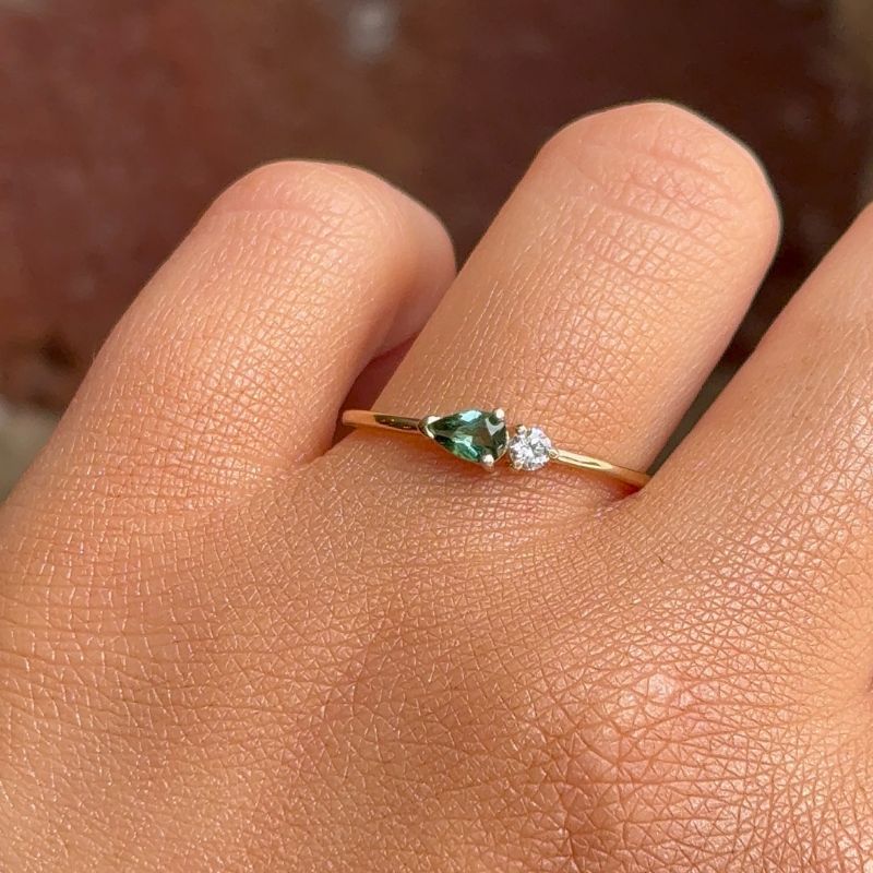 
                  
                    Load image into Gallery viewer, A petite pear tourmaline and round diamond ring shown hand for scale.
                  
                