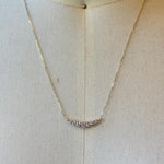 This 7 diamond half moon necklace is set in 14kt yellow gold.