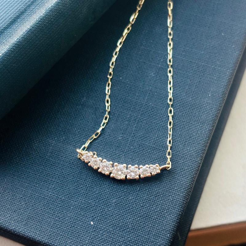 This 7 diamond half moon necklace is set in 14kt yellow gold.