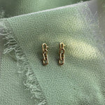 14kt yellow gold chain studs shown on a blue-green linen.