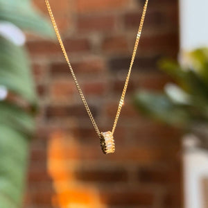 
                  
                    Load image into Gallery viewer, Randi rondel on 14kt gold chain with brick and plants in the background.
                  
                