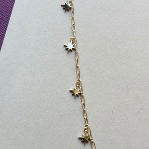 
                  
                    Load image into Gallery viewer, North star charm bracelet laid flat on a white and maroon book.
                  
                