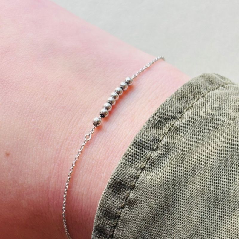 Sterling silver beaded bracelet on model's right wrist.