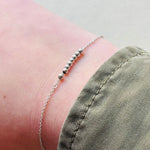 Sterling silver beaded bracelet on model's right wrist.