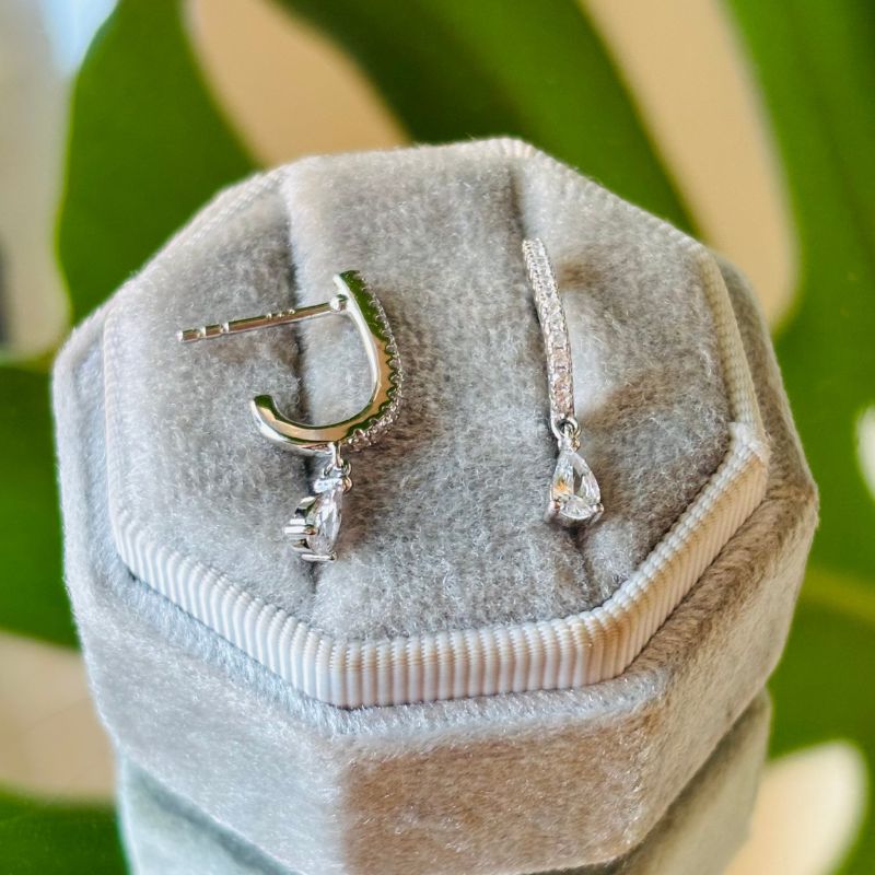 
                  
                    Load image into Gallery viewer, Sterling silver crystal studded style drop studs with a pear hanging crystal shown on gray velvet tray.
                  
                