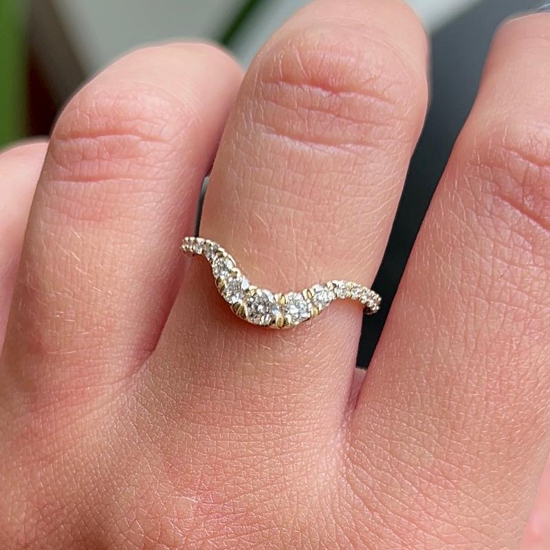 This 14 kt gold shadow band is adorned with 23 round cut white diamonds. The unique curvature of this ring allows it to rest perfectly against several of our gemstone rings. A beautiful complement to an engagement ring, yet looks amazing when worn by itself as well.