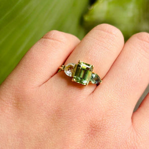 
                  
                    Load image into Gallery viewer, With a piercing green, emerald cut center tourmaline stone, we love the asymmetrical the half moon and pear cut sapphires. A one of a kind beauty sure to be loved for years to come.
                  
                