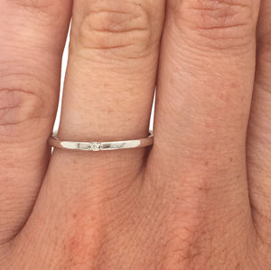 
                  
                    Load image into Gallery viewer, 14 Kt white gold staking band with single diamond on a ring finger.
                  
                